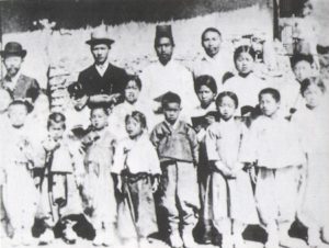 Kim Ku (back row, without hat) as a farmer and teacher in a small town near Haeju, 1906